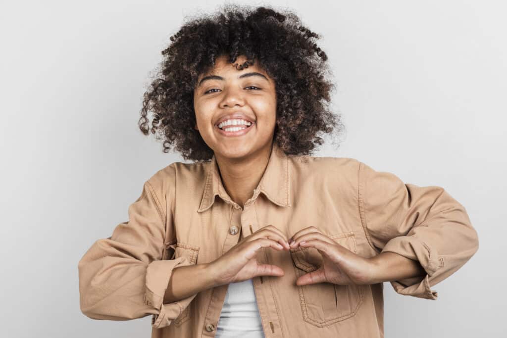 smiling-young-woman-making-hearth-sign